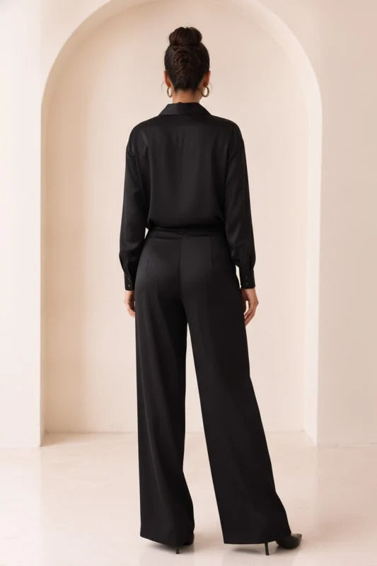 Conjunto satinado negro con blusa cruzada y pantalón amplio